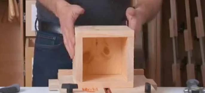 An assembled open-top wooden keepsake box with four sides around a bottom.