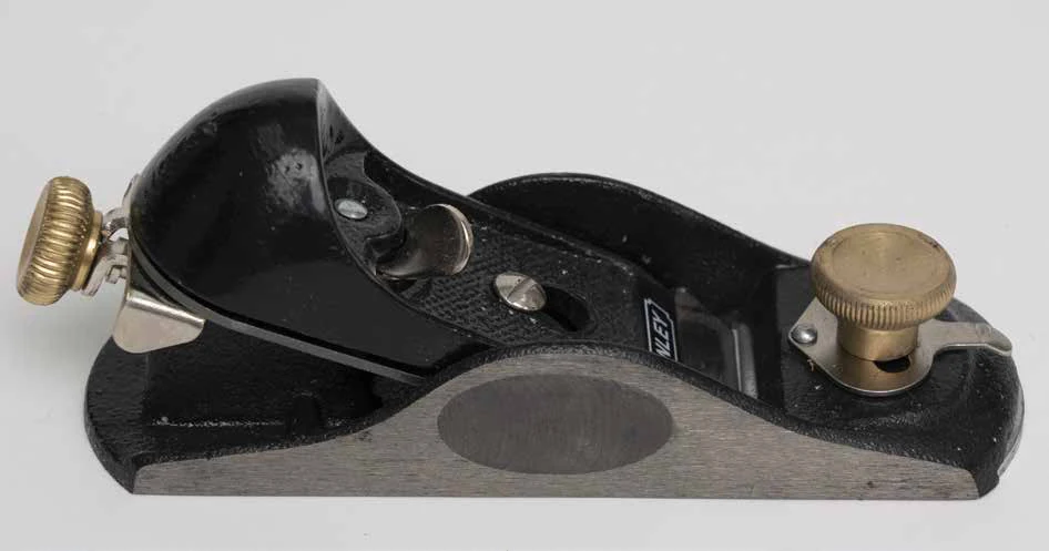 Maplewoodshop photograph of a small block plane with a brass front knob and metal sole.