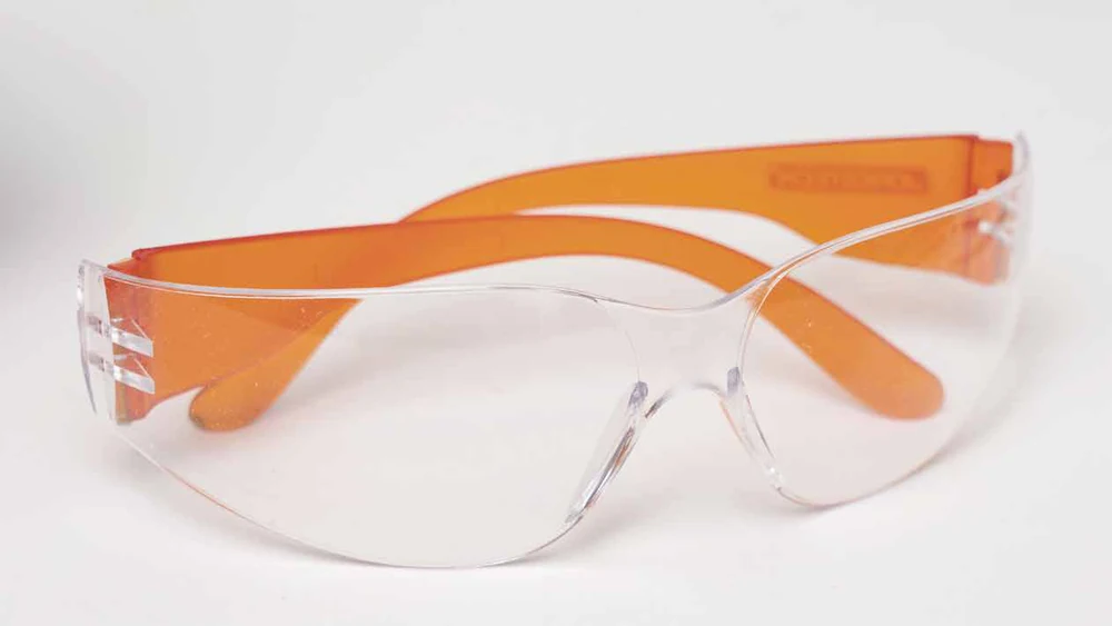 Maplewoodshop identification photograph of clear eye protection with orange arms.