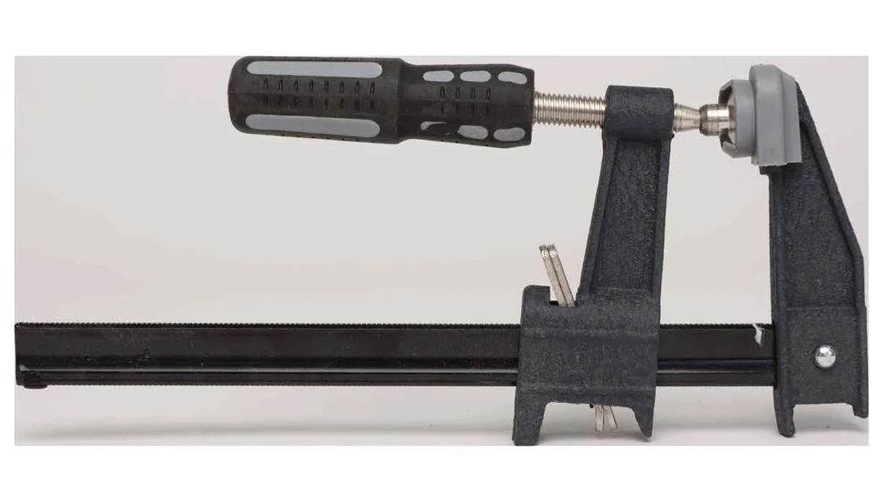 Maplewoodshop photograph of an F clamp with fixed and sliding jaws on a bar.