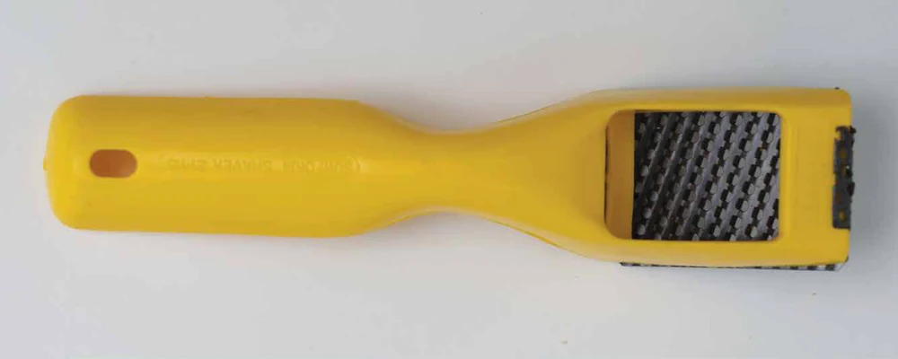 Maplewoodshop photograph of a yellow-handled rasp with a coarse cutting surface.